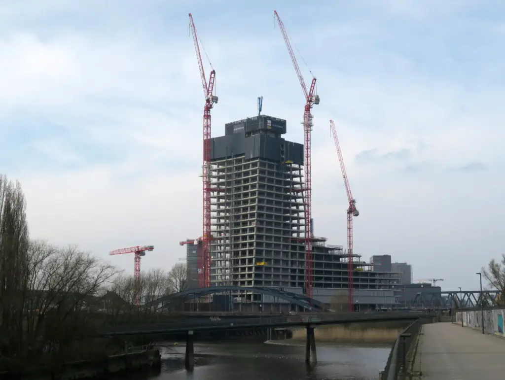 Unfertiger Betonrohbau des Elbtowers mit stillstehenden Kränen, aufgenommen von Westen über die Elbbrücken