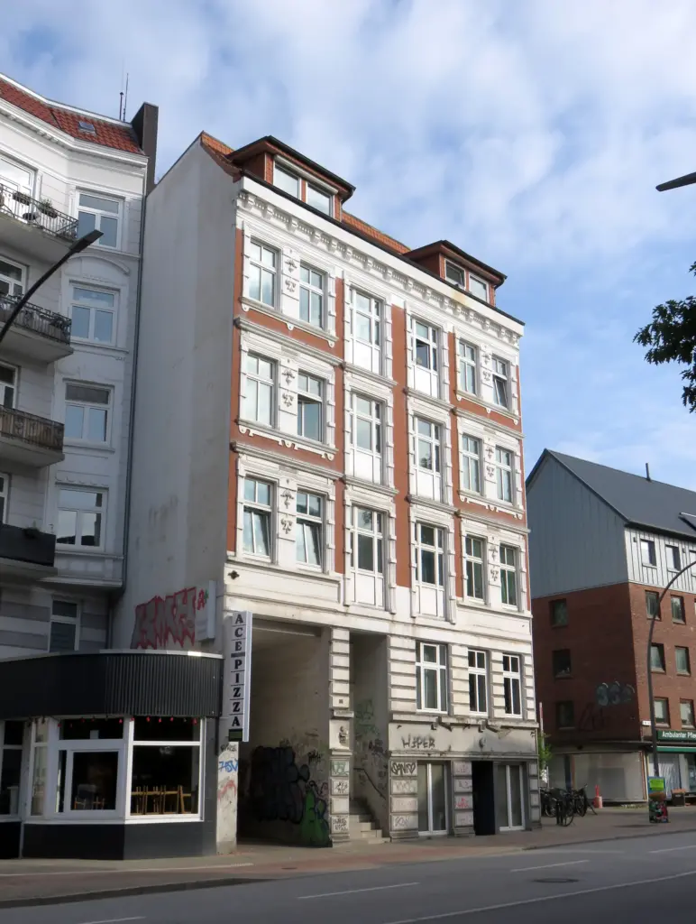 Fassade eines Etagenhauses in Hamburg-Hoheluft-West, links über der Durchfahrt eine Wandrosette