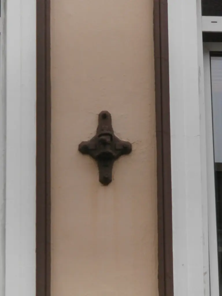 Gusseiserne Oberleitungsrosette mit Blattornament an einer Hausfassade in Hamburg-Ottensen